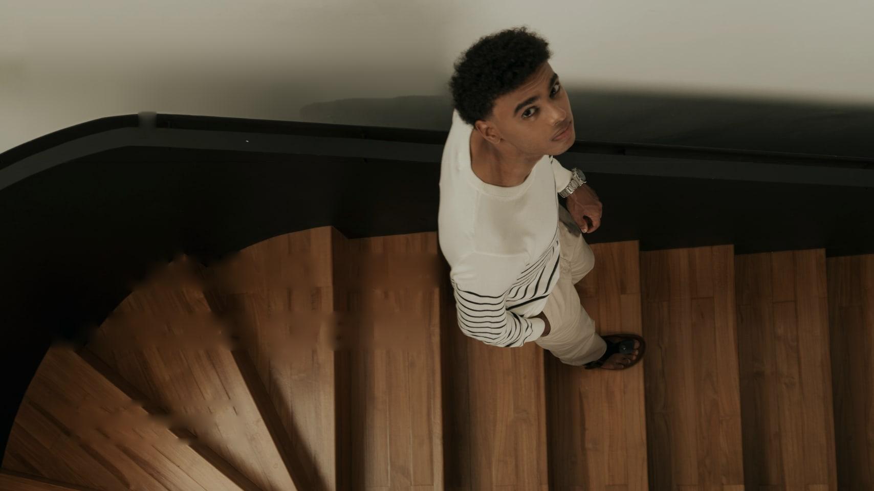 Una persona sube por una escalera de madera y mira hacia arriba